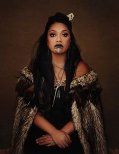 a woman with long black hair wearing a fur coat and piercings on her nose