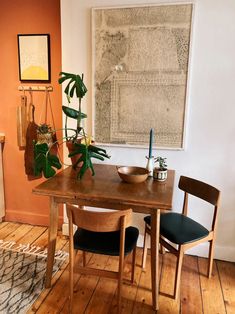 a dining room table with two chairs and a bowl on the table next to it