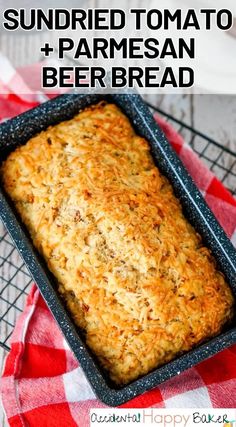 a loaf of sun dried tomato and parmesan beer bread in a baking pan