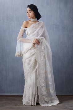 Off white off shoulder blouse with floral embroidered motifs, bell sleeves and sweetheart neckline.
Components:1
Pattern:Embroidered
Type of Work:Floral
Neckline:Sweetheart
Sleeve Length:Bell Sleeves
Fabric:Tulle
Color:White
Other Details:
Scallop border
Note: Saree worn by the model is not for sale
Occasion:Wedding - Aza Fashions Anita Dongre, Wedding Blouse Designs, Wedding Court, White Saree, Wedding Blouse, Elegant Saree, White Tulle, Stylish Sarees, Organza Saree