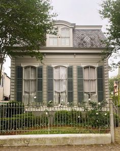 an old house with green shutters on the front