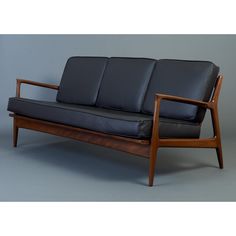 a black leather couch sitting on top of a wooden frame