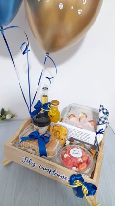 a wooden tray filled with food and balloons