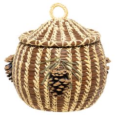 a large woven basket with pine cones on the top and bottom, sitting in front of a white background