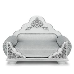 a white couch with silver trimmings and an ornate design on the armrest