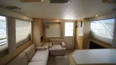 the inside of a recreational vehicle with couches and windows