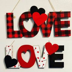 two red and black love signs hanging on a wall next to each other with hearts