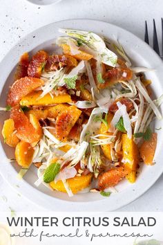 a white plate topped with shaved carrots and other food next to utensils