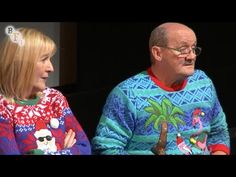 an older man and woman sitting next to each other on a couch in ugly sweaters