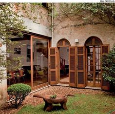 an outside courtyard with wooden shutters and tables