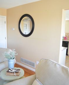 a living room filled with furniture and a mirror