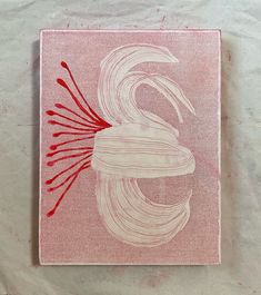 a red and white drawing on a piece of paper that looks like a bird with long hair