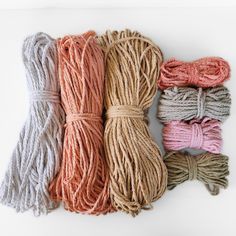 four skeins of multicolored yarn are lined up on a white surface