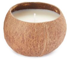 a close up of a candle in a coconut shell on a white background with clippings