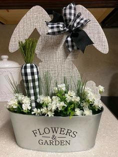 a metal bucket filled with flowers and greenery