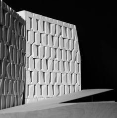 a close up view of a building made out of white bricks and concrete blocks on a black background