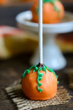 orange cake pops with green icing on a table