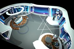 an aerial view of a television studio with two people in the center and several monitors on the walls