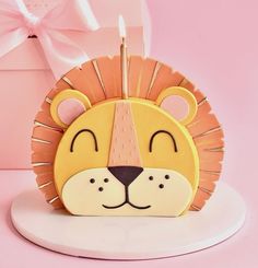 a lion shaped candle holder with a pink box behind it and a bow on the side