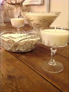 three glass dishes and one candle on a wooden table