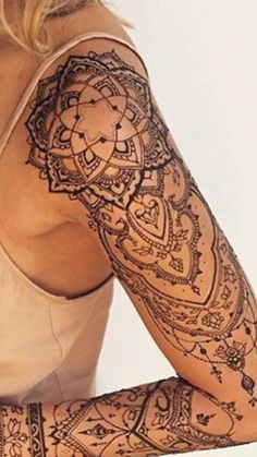 a woman's arm with hendix tattoos on her body and arms,