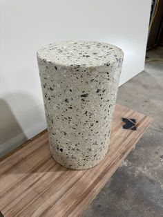 a large concrete vase sitting on top of a wooden table