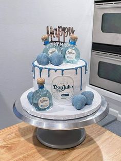 there is a cake with blue decorations on it and two bottles next to the cake