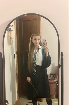 a woman taking a selfie in front of a mirror wearing a harry potter costume