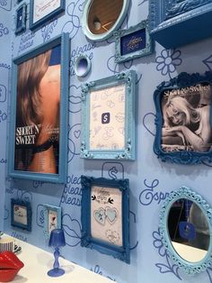 a blue wall with pictures and mirrors on it