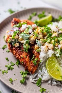 a plate topped with rice and meat covered in cilantro, lime wedges