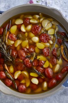 a pot filled with tomatoes and corn on top of a table