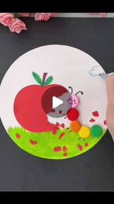 someone is drawing an apple on a paper plate