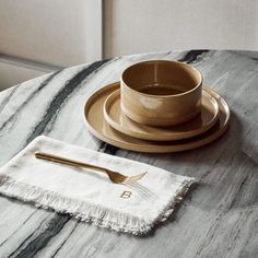 a table with a plate, fork and cup on it next to a white napkin