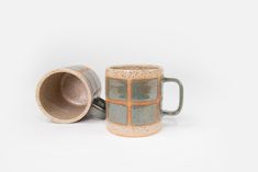 two mugs sitting next to each other on a white surface