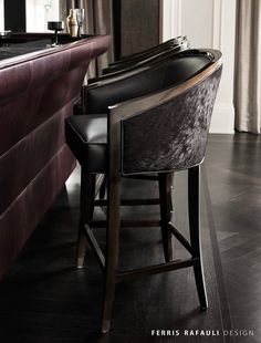 the bar stools are next to the counter in the room with two wine glasses on it