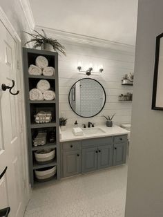 a bathroom with gray cabinets and white walls