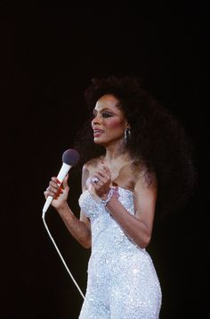 a woman in a white dress holding a microphone