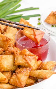 some food is sitting on a plate with chopsticks and ketchup in it