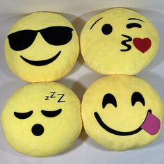 four yellow smiley face pillows with hearts and sunglasses on them, one has a pink heart