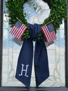 a wreath with the letter h and an american flag on it