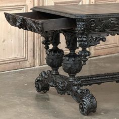 an ornately carved wooden table with two drawers on one side and three legs at the other end