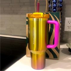 a metallic coffee cup sitting on top of a counter next to a bag and knife