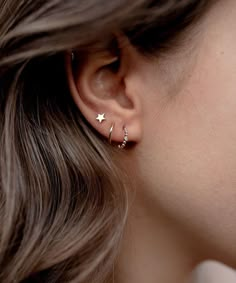 a close up of a woman's ear with two small stars on the side