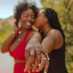 two women in red dresses holding hands with each other