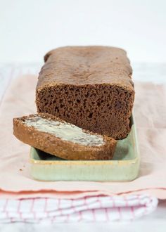 a loaf of bread sitting on top of a plate next to a piece of bread