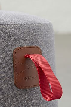 a red ribbon is attached to the back of a gray chair with a brown leather tag on it