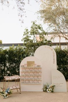 an outdoor ceremony setup with a sign and flowers