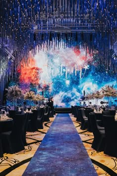 a long table with black chairs and chandelier hanging from the ceiling