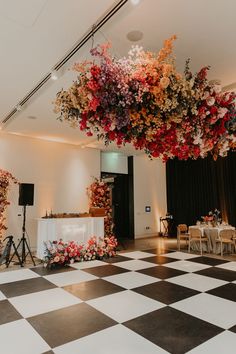 a black and white checkered floor with flowers hanging from the ceiling