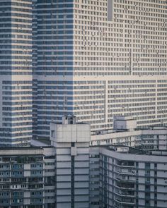 an airplane flying over the top of tall buildings in front of other skyscrapers,